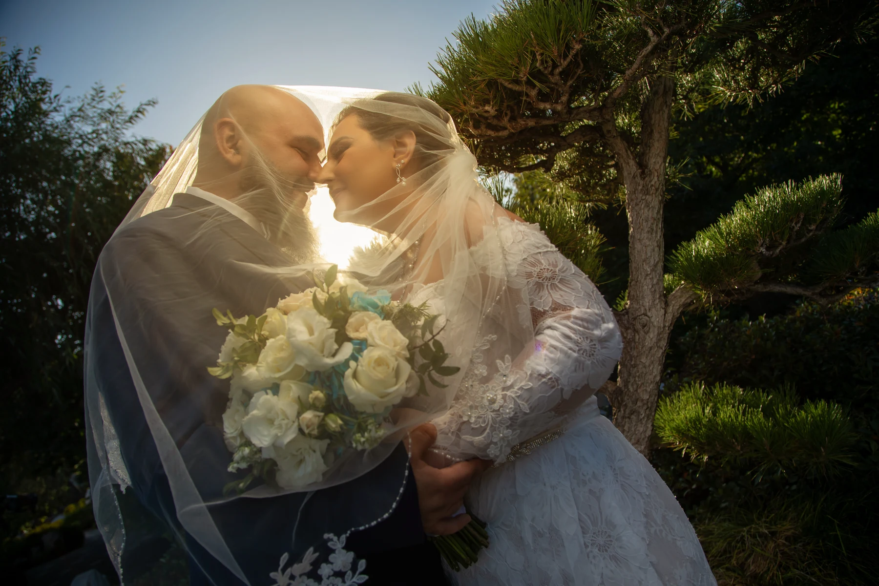 A bride and groom posing on grand museum steps during a golden-hour wedding photo session